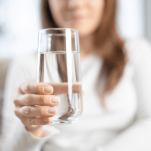 A person pouring juice into a glass