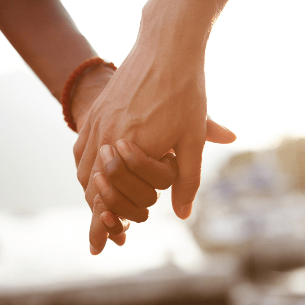 Two people holding hands as a sign of comfort